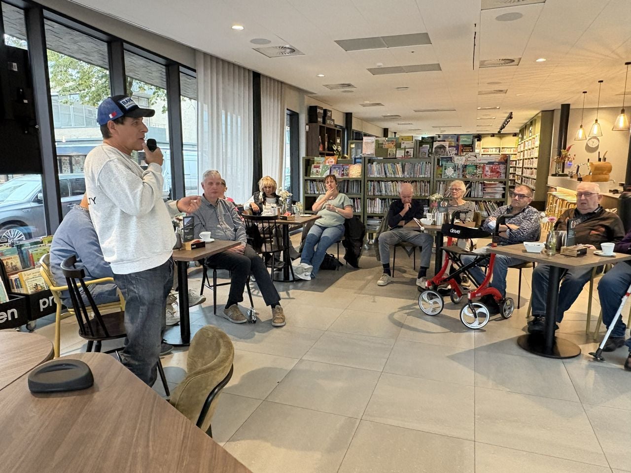 Jos vertelt over zijn ervaringen met de AI-bril tijdens de maandelijkse bijeenkomst van het Oogcafé. (foto: Karin Kamp).