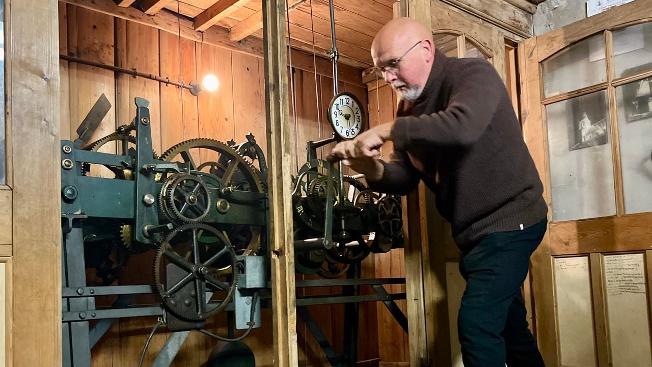 Theo van der Rijk draait aan het uurwerk om de klok een uur terug te zetten (foto: Eva de Schipper).