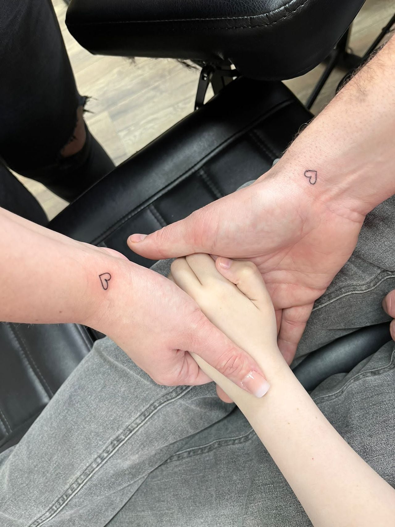 De tattoos van Maartje en Danny, met de hand van Lynn in het midden (Privéfoto).