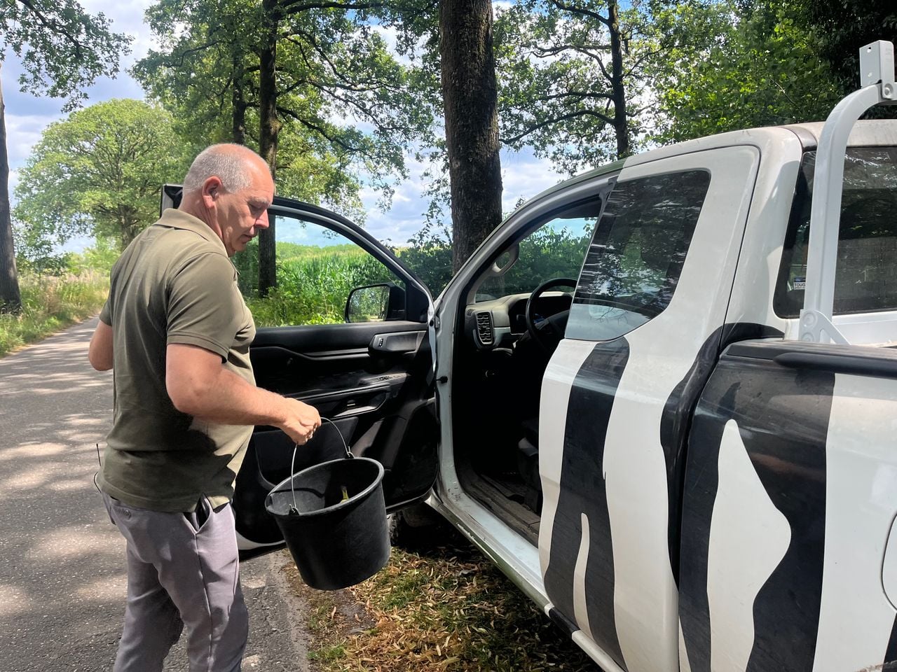 Martin vult het voedsel in de kooi aan met lekkere hapjes voor de kuifmangabey (foto: Floortje Steigenga).