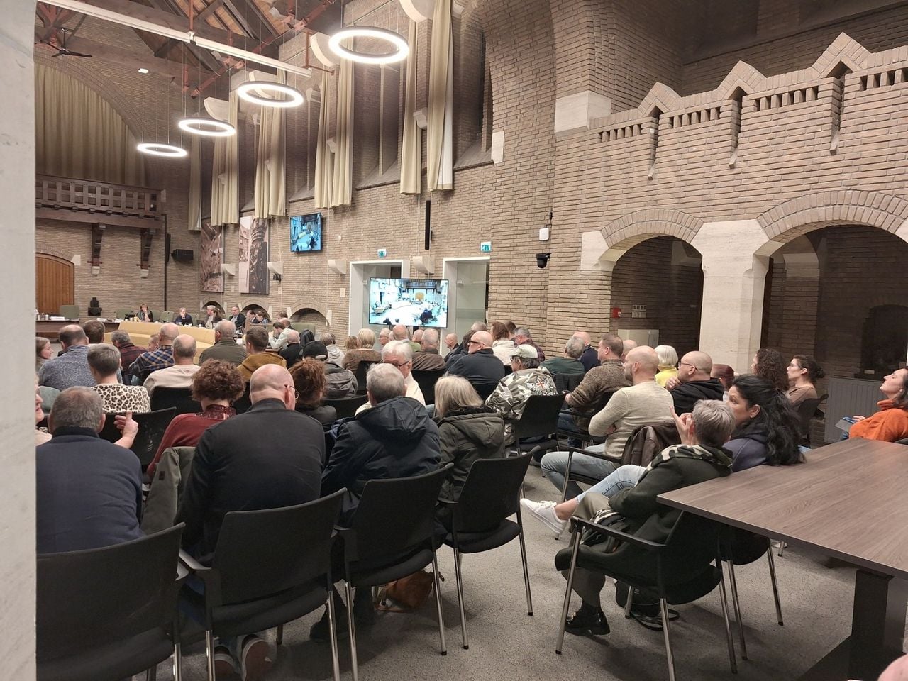 Een volle publieke tribune kijkt en luistert mee (foto: Dorpsplatform Putte).