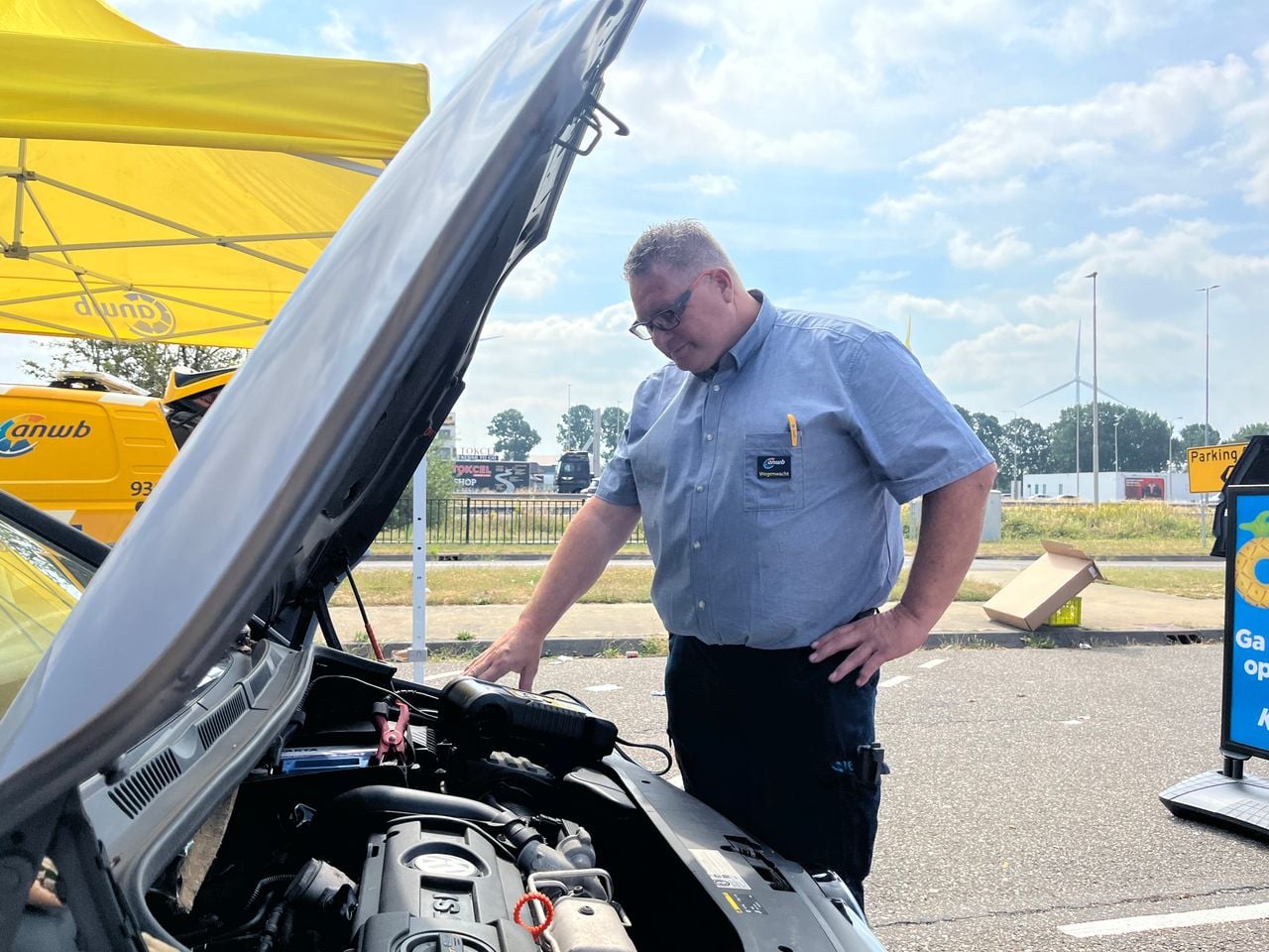 René checkt de accu van een auto. (foto: Floortje Steigenga)