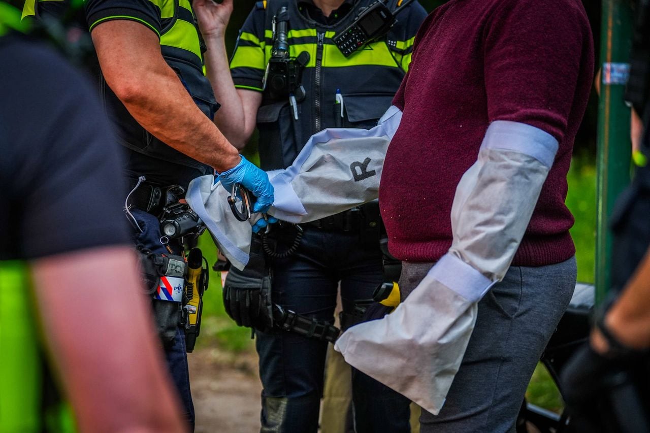De verdachte heeft zakken om zijn armen gekregen, zodat er sporen kunnen worden opgenomen (foto: Persbureau Heitink).