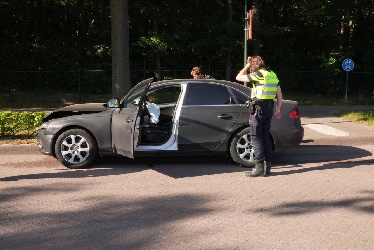De politie buigt zich over een van de wagens (foto: Harrie Grijseels/Persbureau Heitink).