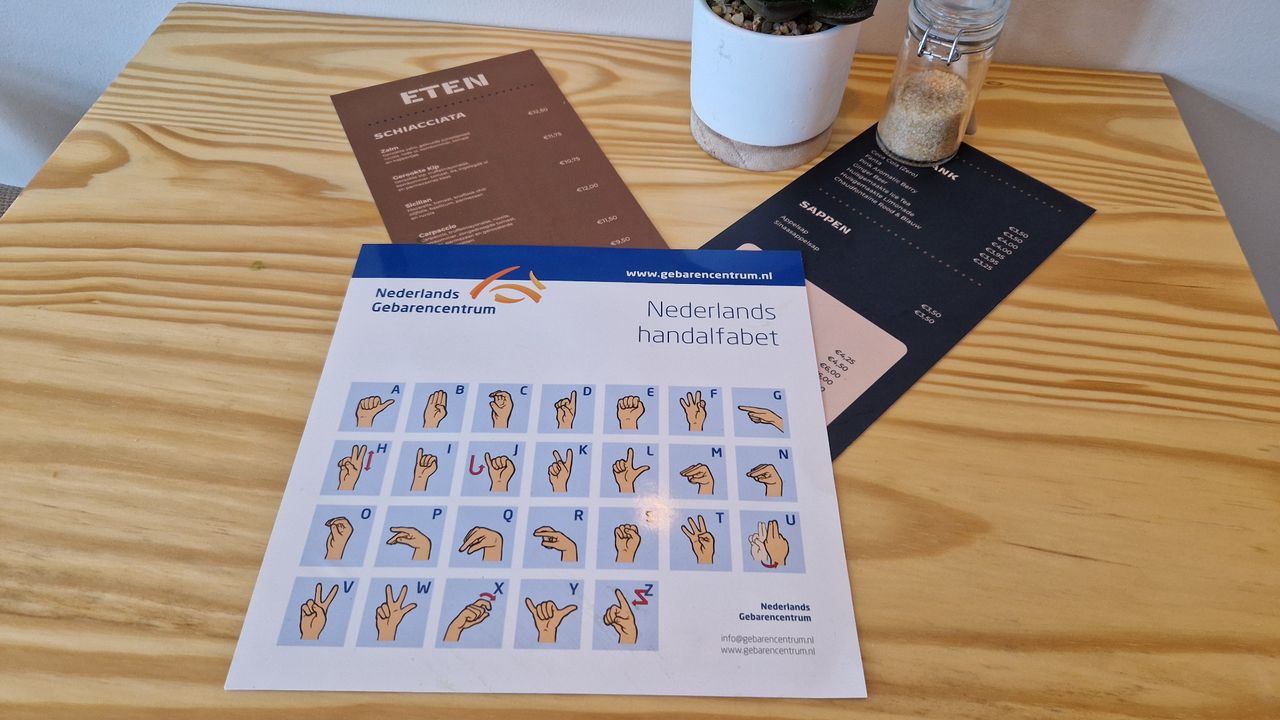 De menukaart ligt op tafel samen met het handalfabet (foto: Tom Berkers).