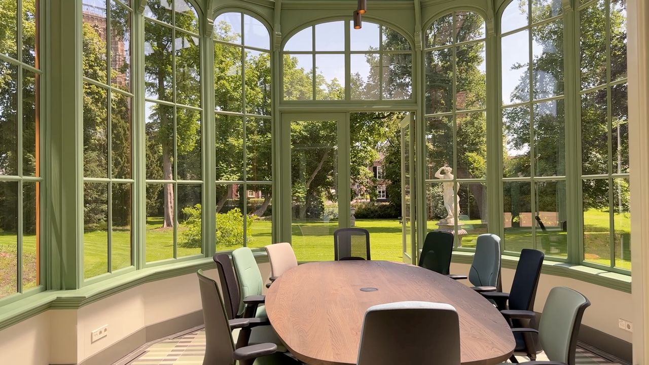 In de glazen serre naast het landhuis staat een strakke vergadertafel met bureaustoelen (foto: Megan Hanegraaf).