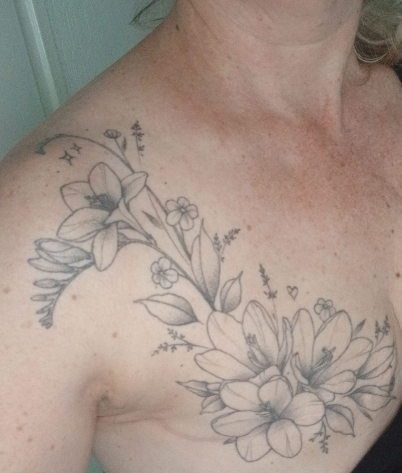 Cynthia's Tittoo verbergt haar litteken. Het hartje staat voor haar dochter en de sterretjes voor haar overleden ouders. De fresia's waren de lievelingsbloemen van haar moeder (eigen foto).