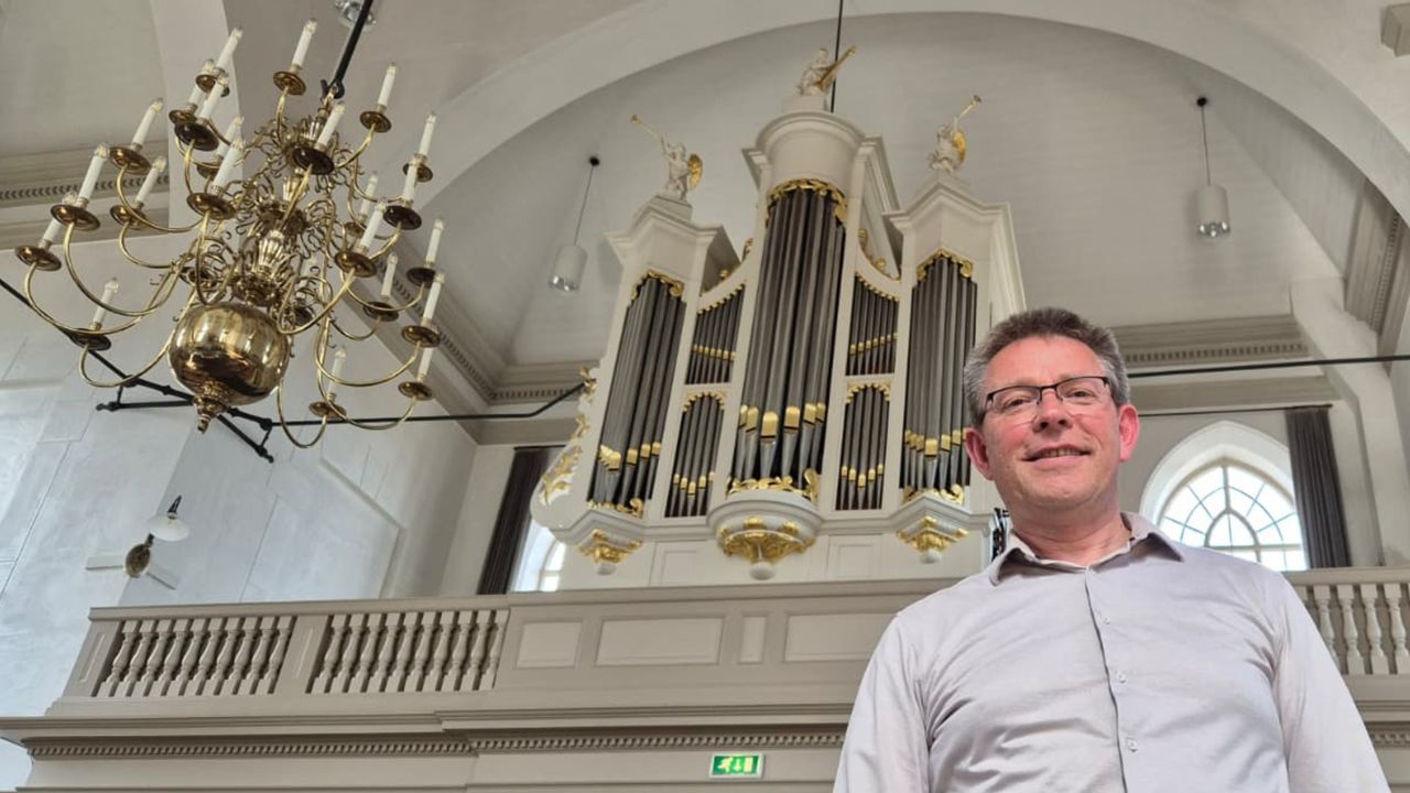 Organist Aad de Ligt voor het orgel in de Protestantse Kerk in Hooge Zwaluwe (foto: Niek de Bruijn)