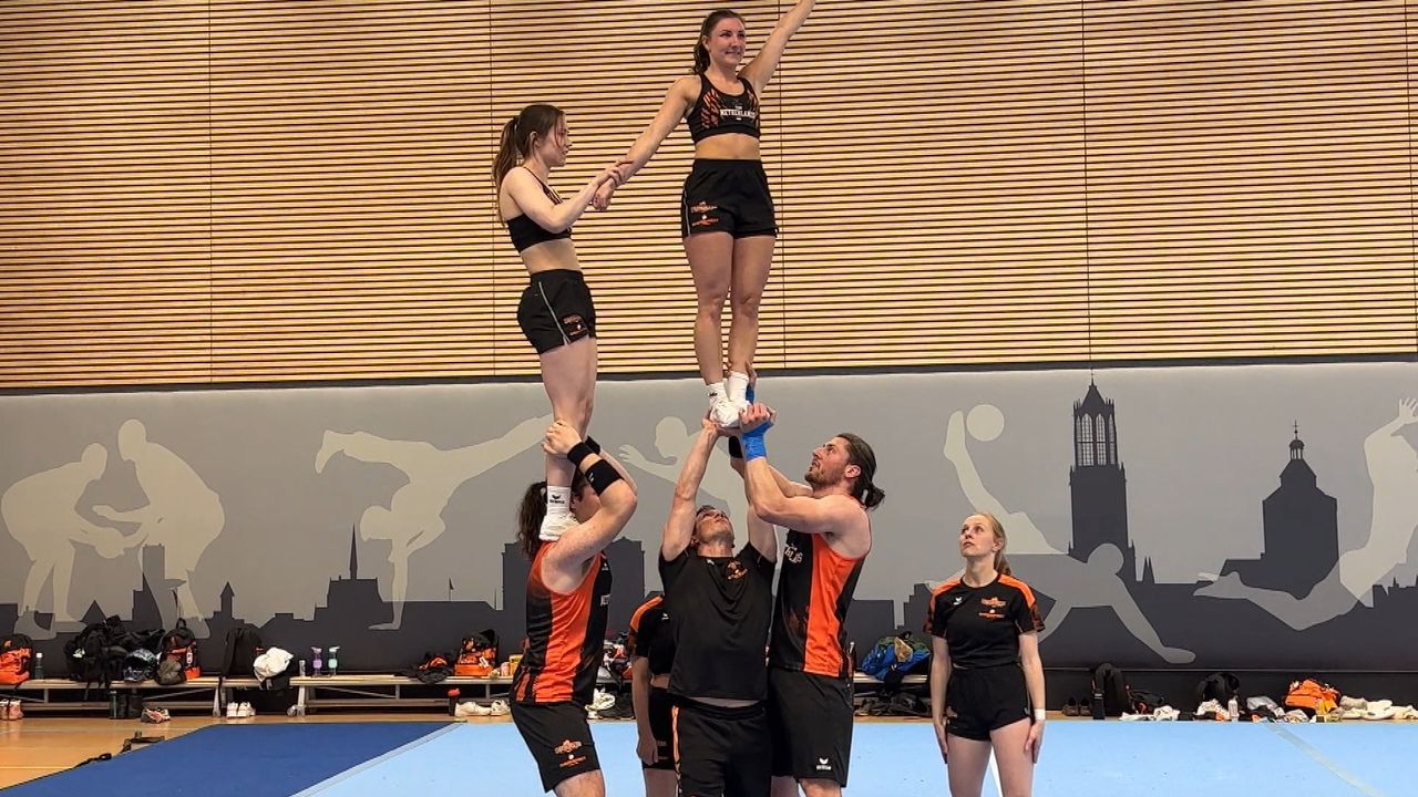 Jens en Karsten (rechts) tillen een teamgenote op.