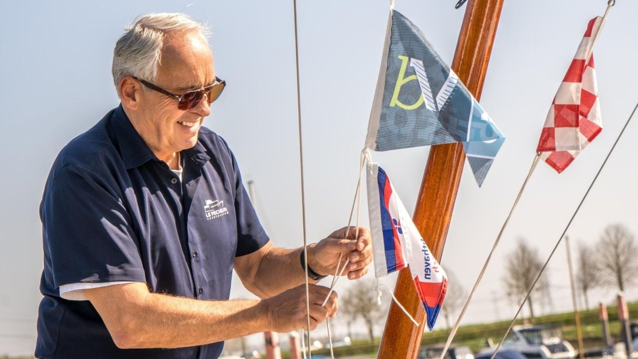 Een bootbezitter bevestigt het Biesbosch Vaantje aan zijn mast in de jachthaven van Drimmelen (foto: Stichting Biesbosch Vaantje)