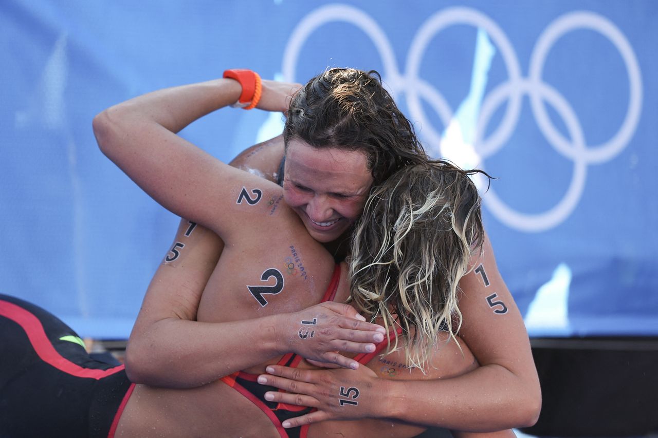 Sharon van Rouwendaal wordt na haar gouden race gefeliciteerd door de Australische Moesha Johnson (foto: ANP 2024/Franck Fife AFP).