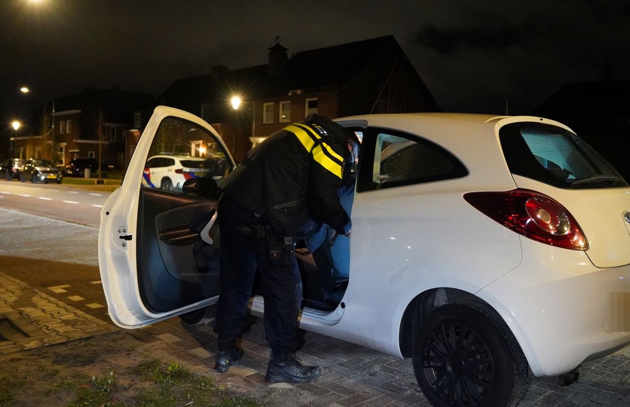 De politie doorzocht vier auto's die voor het huis stonden (foto: Bart Meesters / Persbureau Heitink).