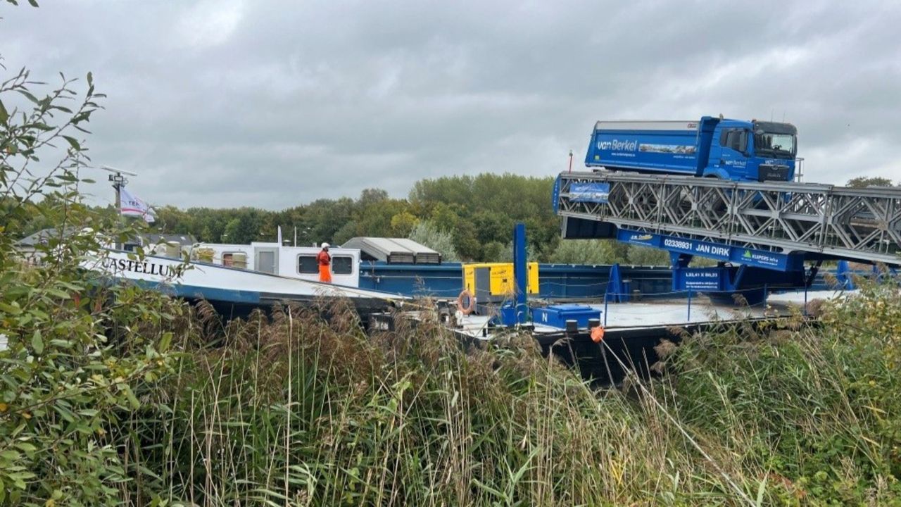 Vrachtwagens vol met zand rijden op een speciaal aangelegde brug om het zand in de boot te krijgen (foto: Waterschap Aa en Maas).