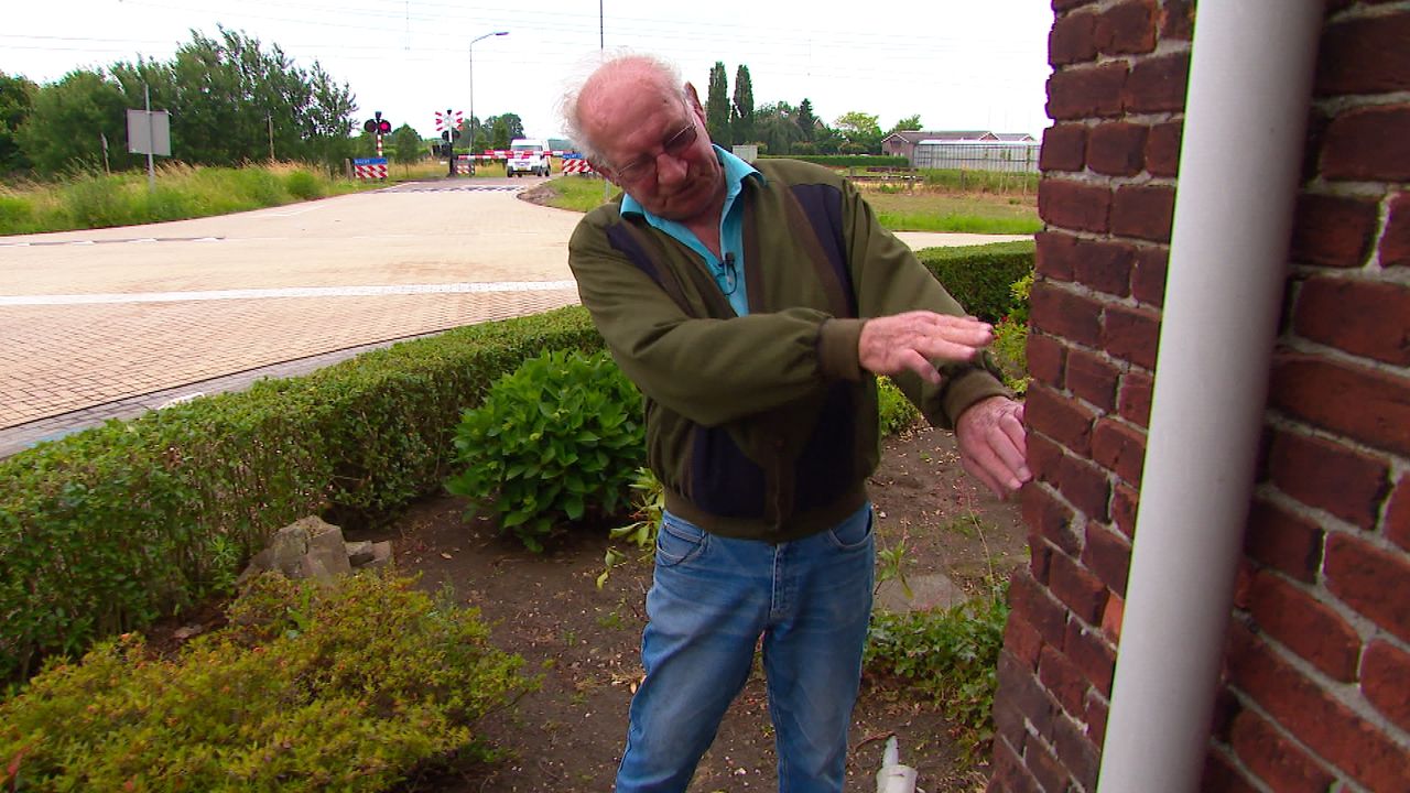 Gerard wijst aan waar de auto tegen zijn gevel belandde (foto: Omroep Brabant).
