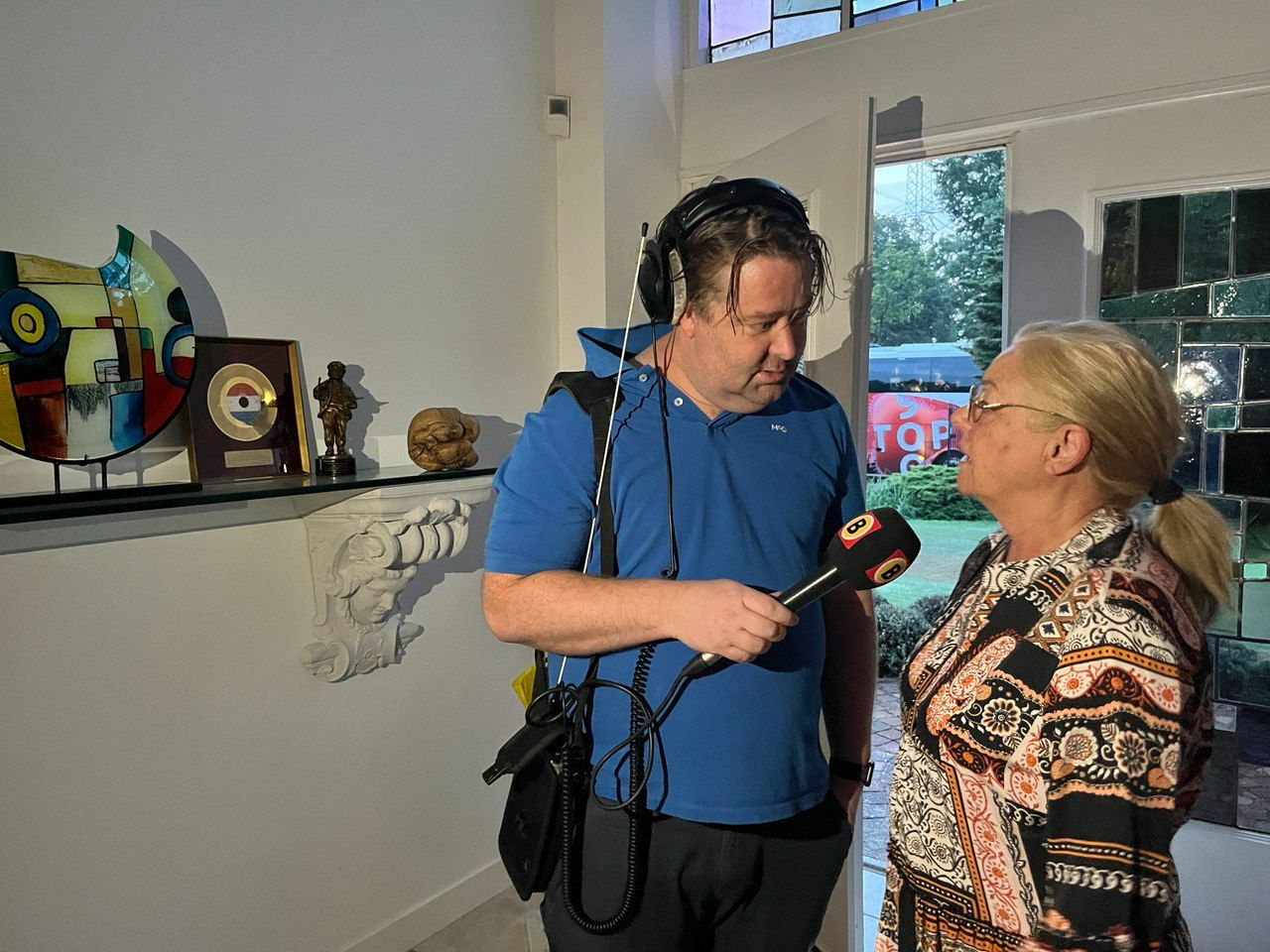 Koen interviewt Corry in de hal. 