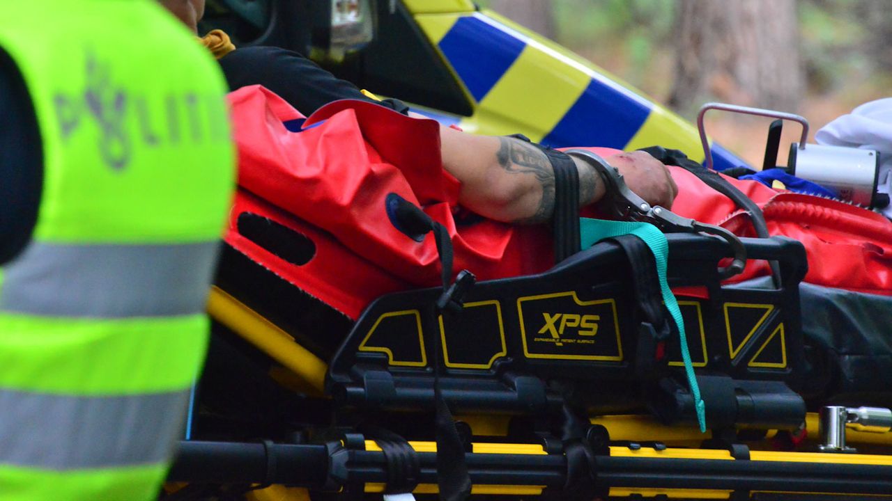 De bestuurder met handboeien op de brancard (foto: Walter van Bussel / SQ Vision).