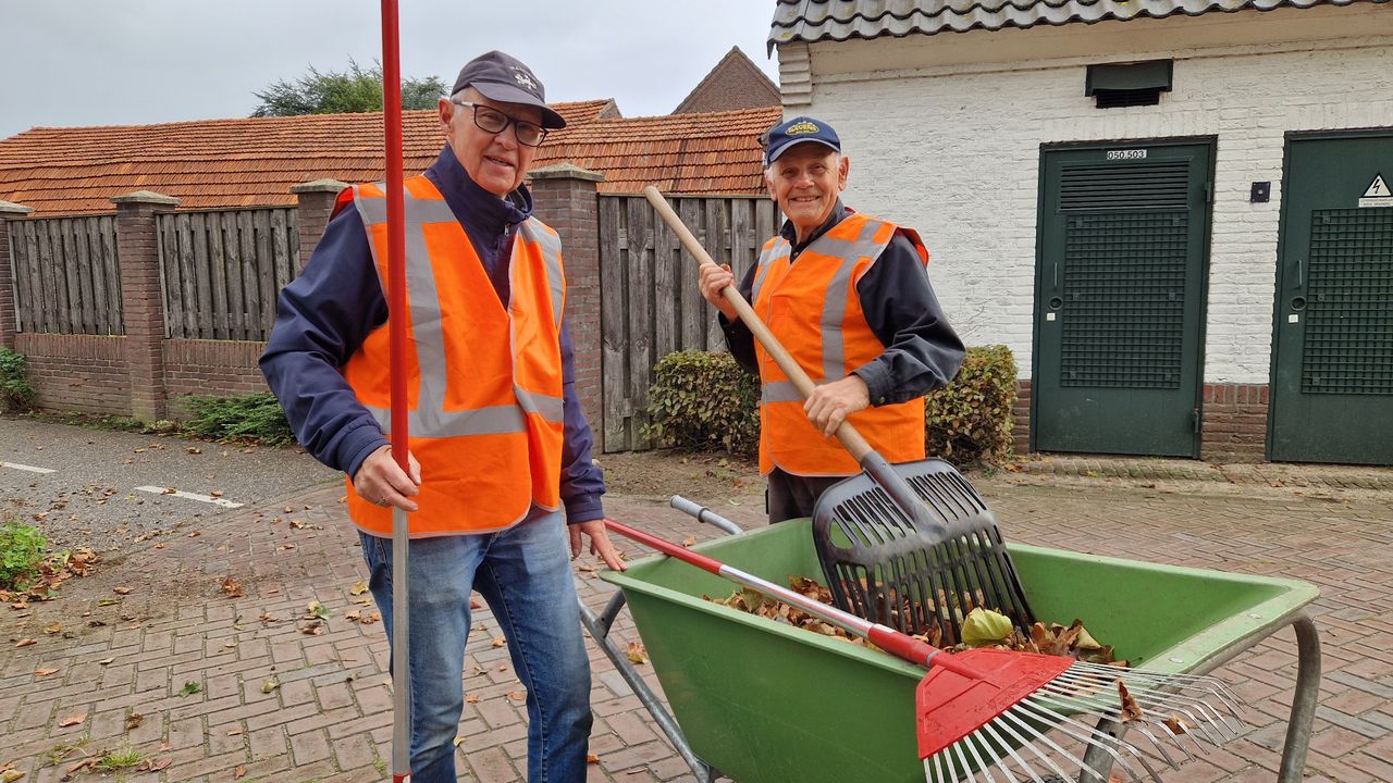 Twee van de vrijwilligers hard aan het werk om de blaadjes op te harken (foto: Tom Berkers).