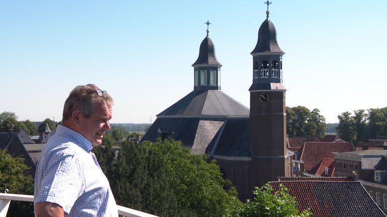 Kees Verhoeckx met op de achtergrond de Sint-Luciakerk.