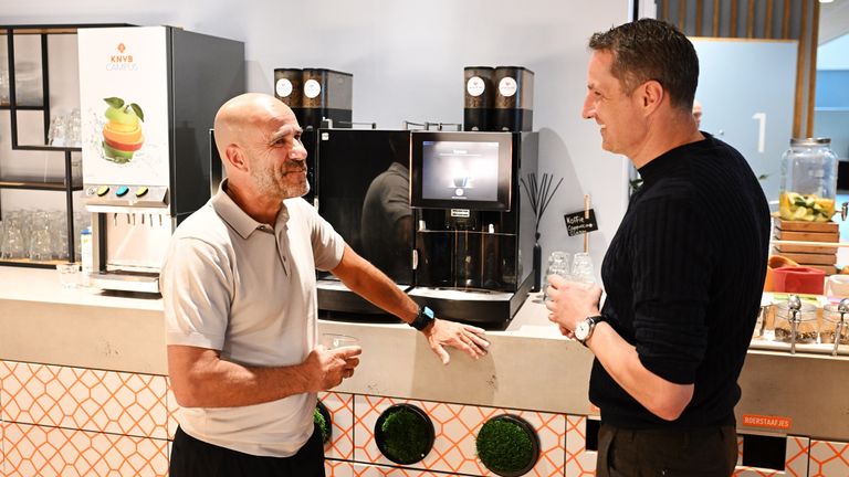 Peter Bosz en Brian Priske leren elkaar kennen bij het koffiezetautomaat (foto: ANP).