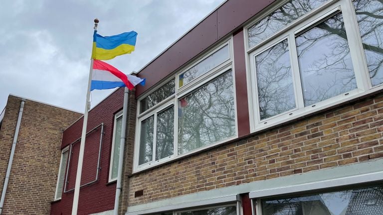 De vlaggen hangen klaar bij de ingang van de school.