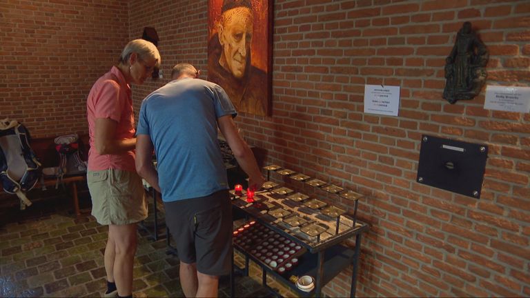 Toeristen steken een kaars aan in de kapel van broeder Everardus (foto: Megan Hanegraaf).