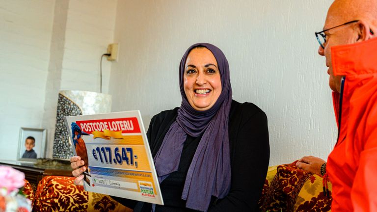 Fatima ontvangt de cheque van 117.647 euro (foto: Postcode Loterij).