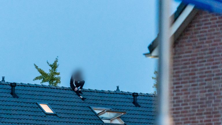 De man zit op het dak (foto: Jack Brekelmans/SQ Vision).