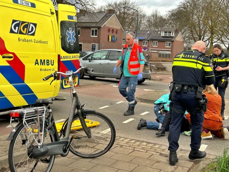 Ambulancemedewerkers en agenten buigen zich over een fietsster die in Veldhoven werd aangereden (foto: Rico Vogels/SQ Vision).