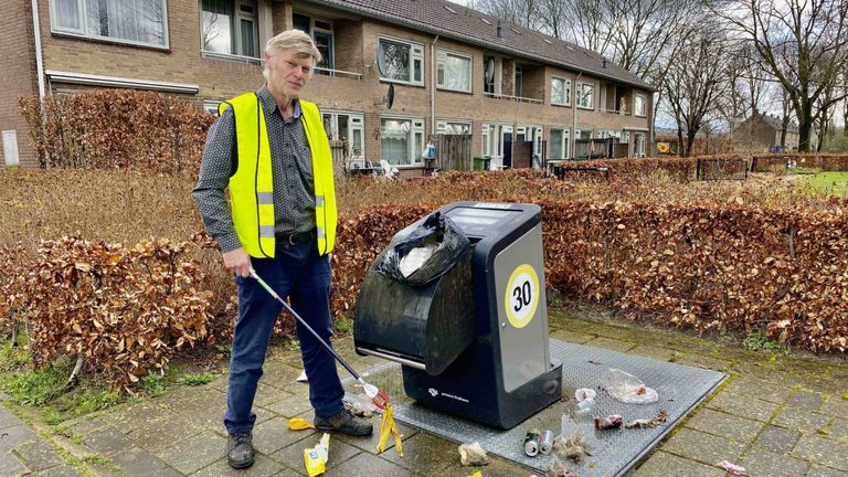 Kees Braam ruim rommel rond de afvalbak in zijn wijk in Eindhoven op (foto: Jan Peels)