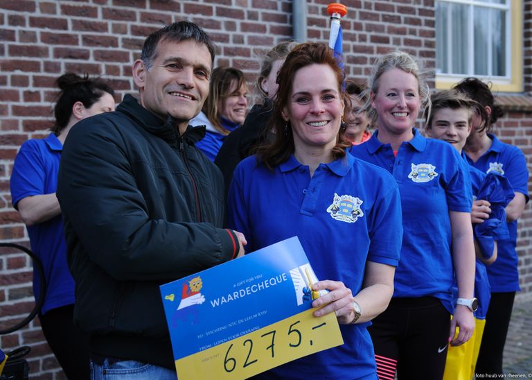 Guido van Engelen is blij met de cheque die Yura Anems (rechts) hem heeft overhandigd (foto: Huub van Rheenen).