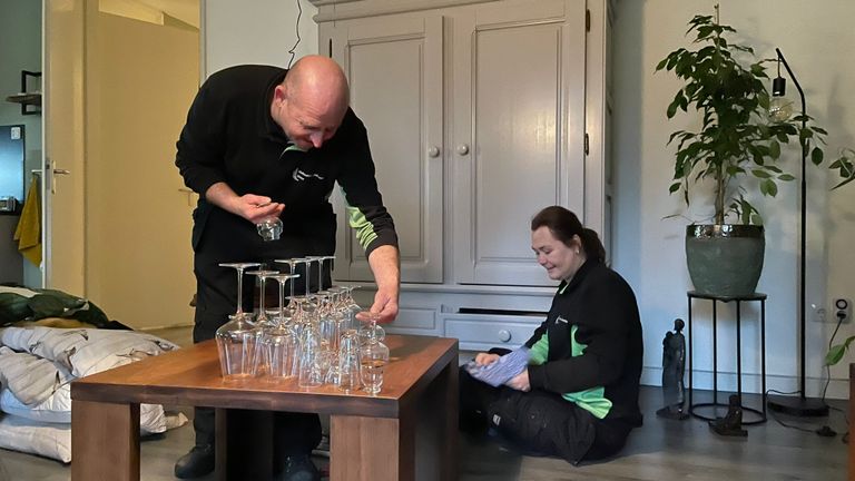 Schoonmakers aan het werk in het appartement van Leny. 