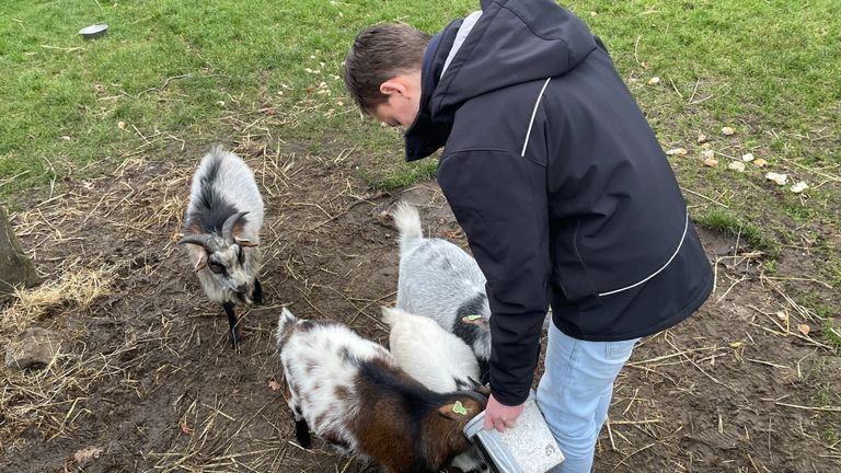 Tim* voert de geiten op de boerderij (foto: Alice van der Plas)