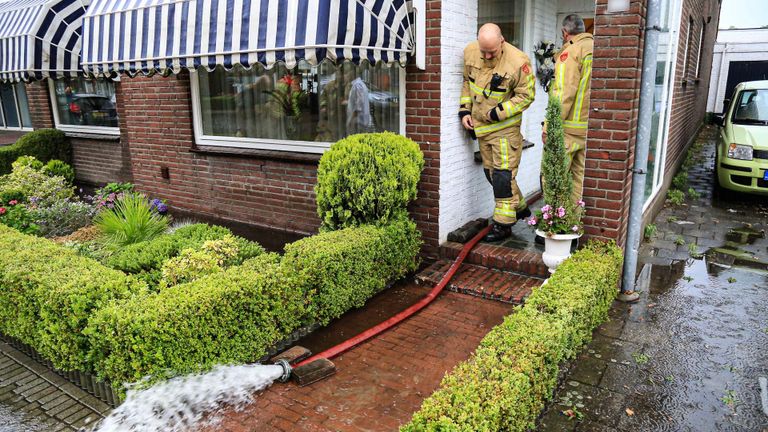 De brandweer pompt water uit een ondergelopen huis (foto: Harrie Grijseels/SQ Vision).