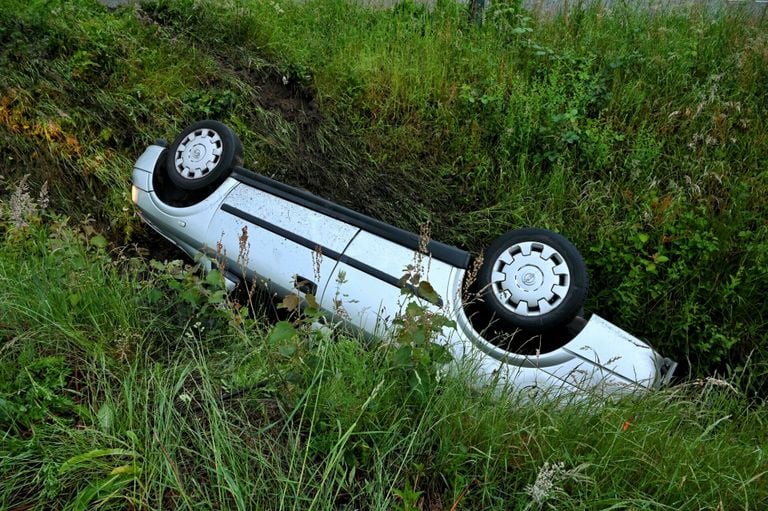 De auto belandde in een greppel naast de Bedrijfsweg in Oisterwijk (foto: Toby de Kort/SQ Vision).