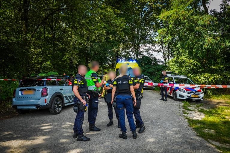 Agenten overleggen met elkaar, voor en achter afzetlint (foto: SQ Vision).