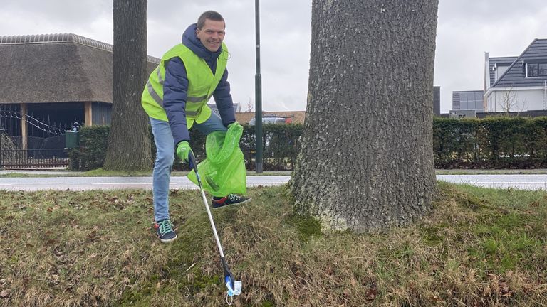 Thijs Huiting vindt een mondkapje aan de waterkant in Son (foto: Jan Peels)