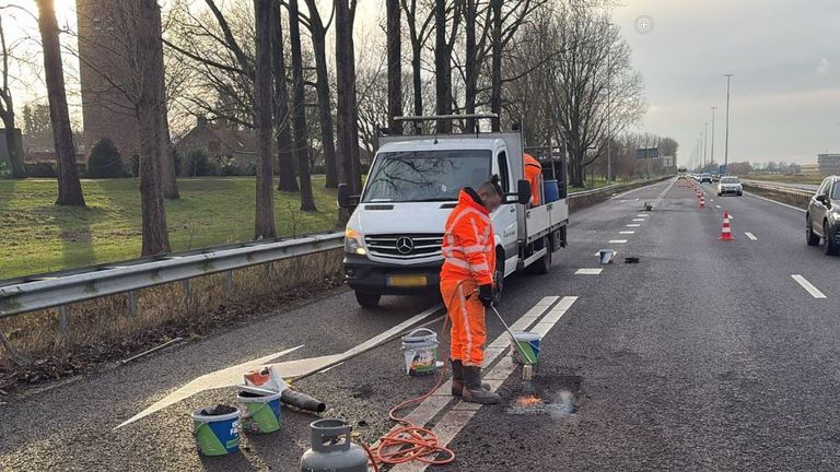 Wegwerkers herstellen het asfalt op de A59 (foto: Rijkswaterstaat).