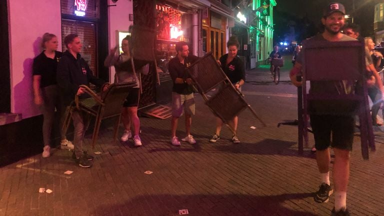 Horecapersoneel sjouwt terrasmeubilair naar het Stadhuisplein in Eindhoven (foto: Imke van de Laar).