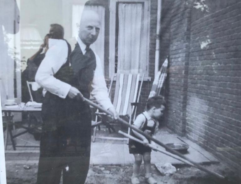 Gerhard van der Rhoer met zijn kleinzoon aan het werk in de tuin.