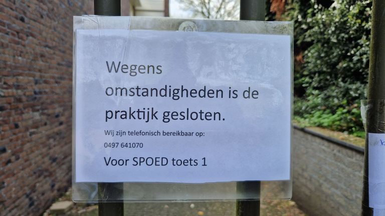 De poort is gesloten, dit briefje verwijst patiënten door.