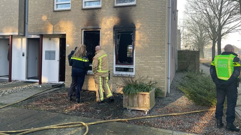 De brandweer en de politie bekijken het uitgebrande hoekpand (foto: René van Hoof).