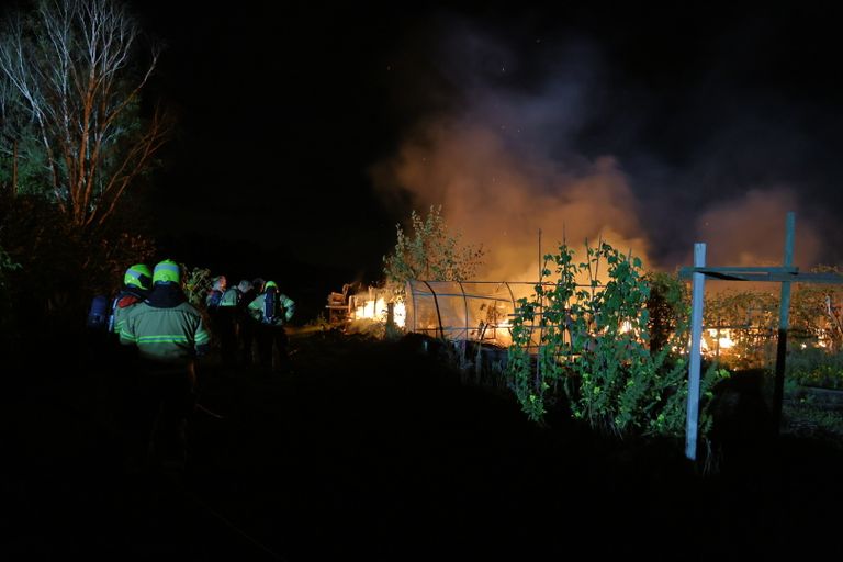 Het duurde anderhalf uur voordat de brand op het volkstuinencomplex in Boxmeer onder controle was (foto: SK-Media).