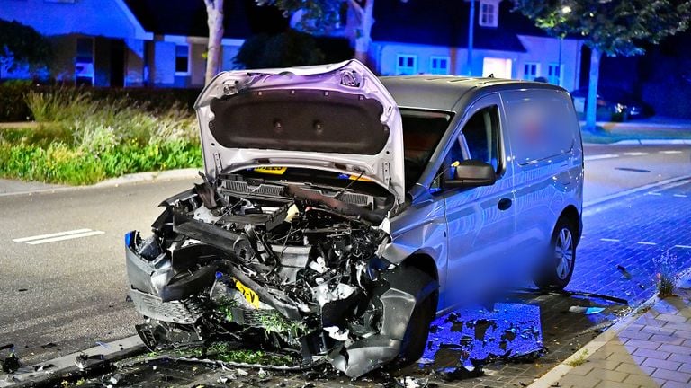 De geparkeerde auto zit na de klap aan de voorkant volledig in elkaar (foto: Rico Vogels / SQ Vision).