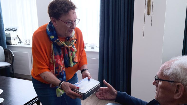 Initiatiefnemer Marie Thérèse Janssen overhandigt de eerste bewoner een welkomstcadeautje (foto: Megan Hanegraaf).