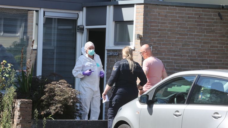 Technisch rechercheurs in witte pakken doen onderzoek in een van de huizen aan de Vierde Haren in Den Bosch (foto: Bart Meesters).