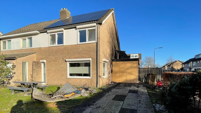 Het huis en de dichtgespijkerde garage met daglicht (foto: Raymond Merkx.).