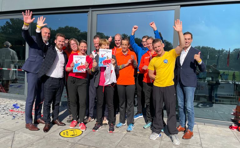 De ambassadeurs bieden het bidboek aan aan de organisatie. (Foto: Omroep Brabant)