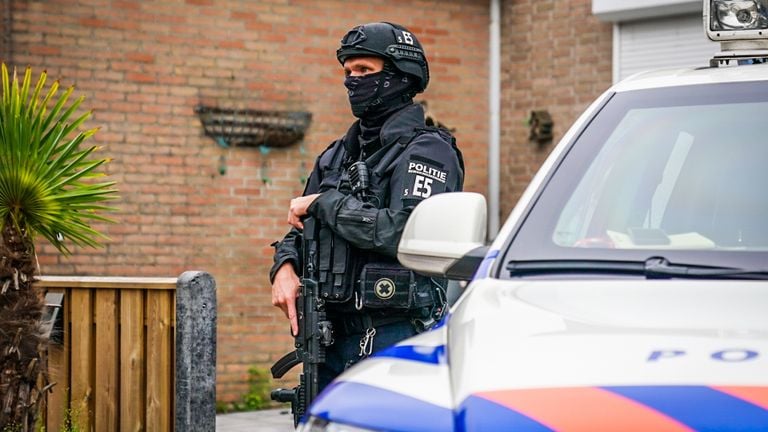 Ook vrijdagochtend staan er zwaarbewapende agenten bij de garageboxen achter de huizen aan de Italiëlaan in Eindhoven (foto: Sem van Rijssel/SQ Vision).