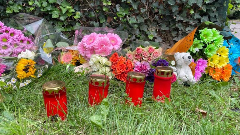 Voor 't Goudvisje liggen bloemen en kaarsjes 