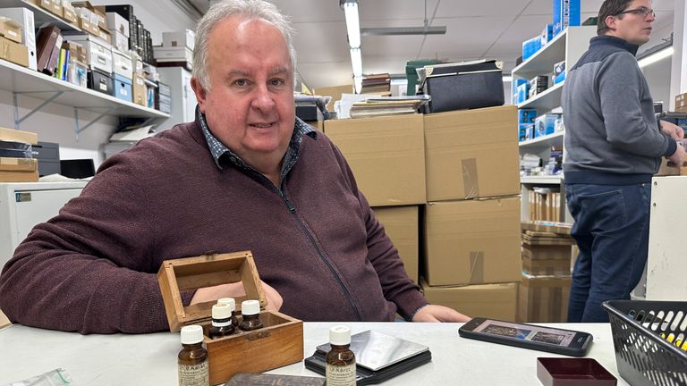 Patrick Sneller met weegschaal, natuursteen en potjes salpeterzuur om de echtheid van het goud te achterhalen.